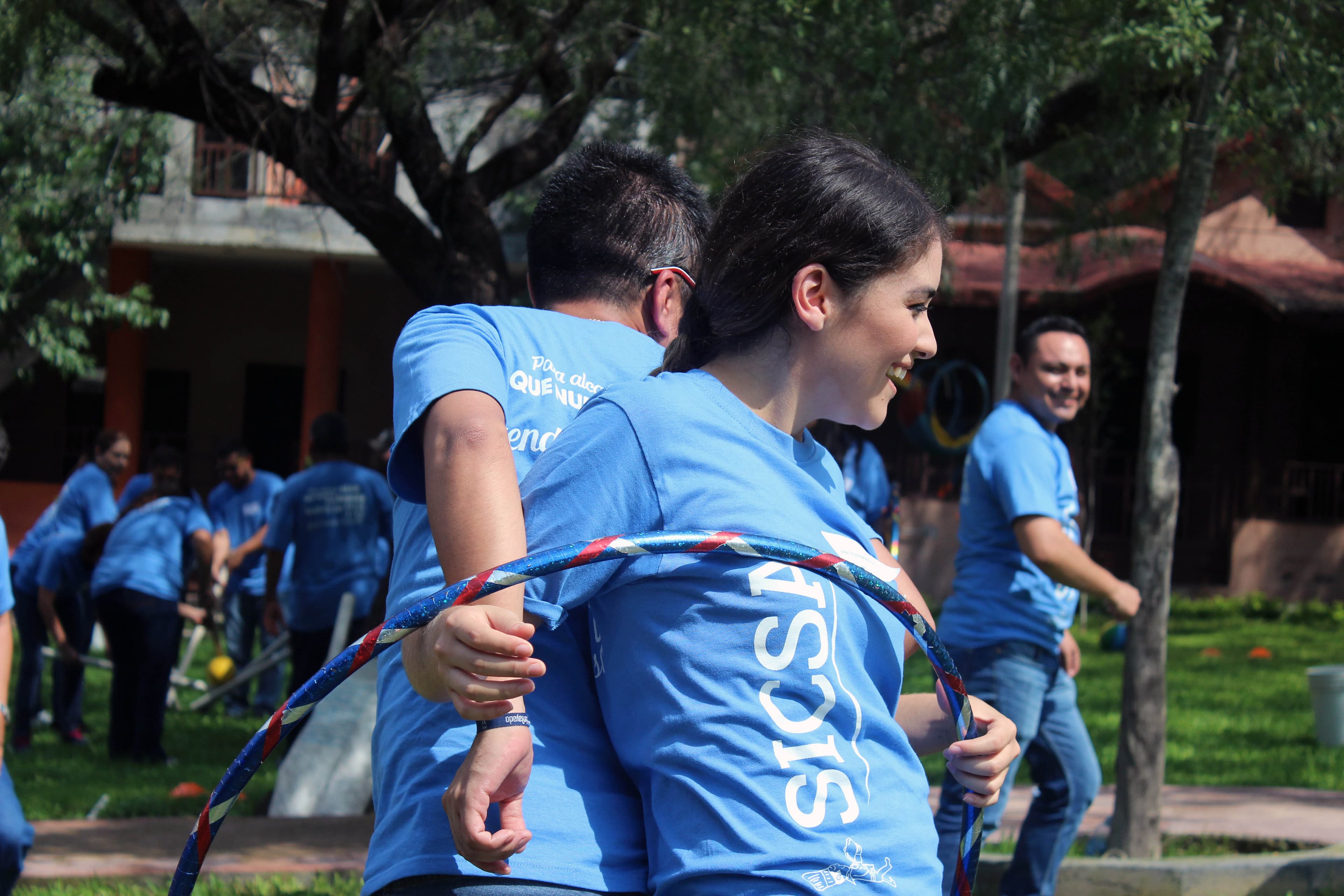 Participantes trabajando juntos para superar un desafío de equilibrio, demostrando confianza mutua y comunicación