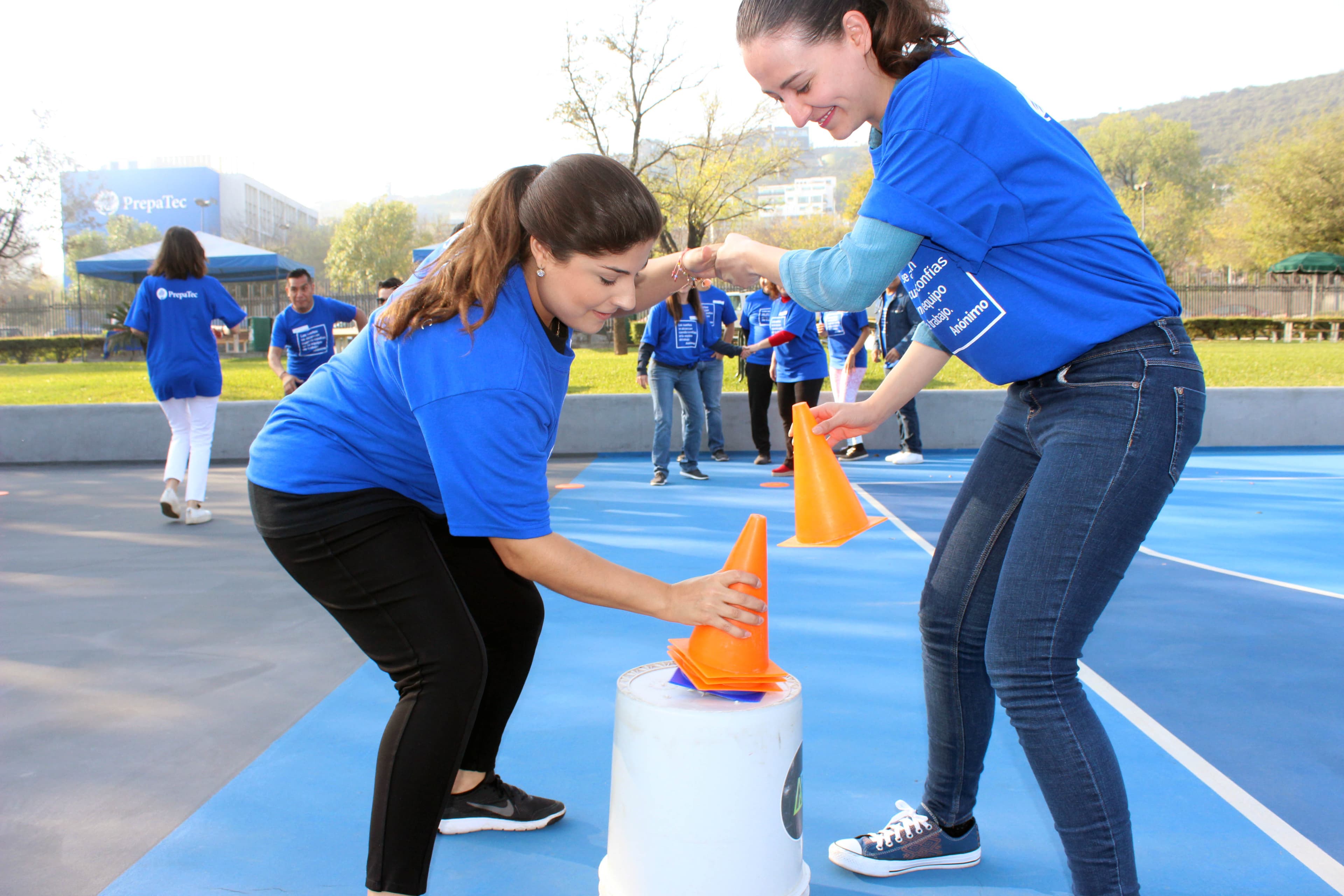 Mujer ayudando a un compañero durante un ejercicio práctico, simbolizando el apoyo y la cooperación en el rally