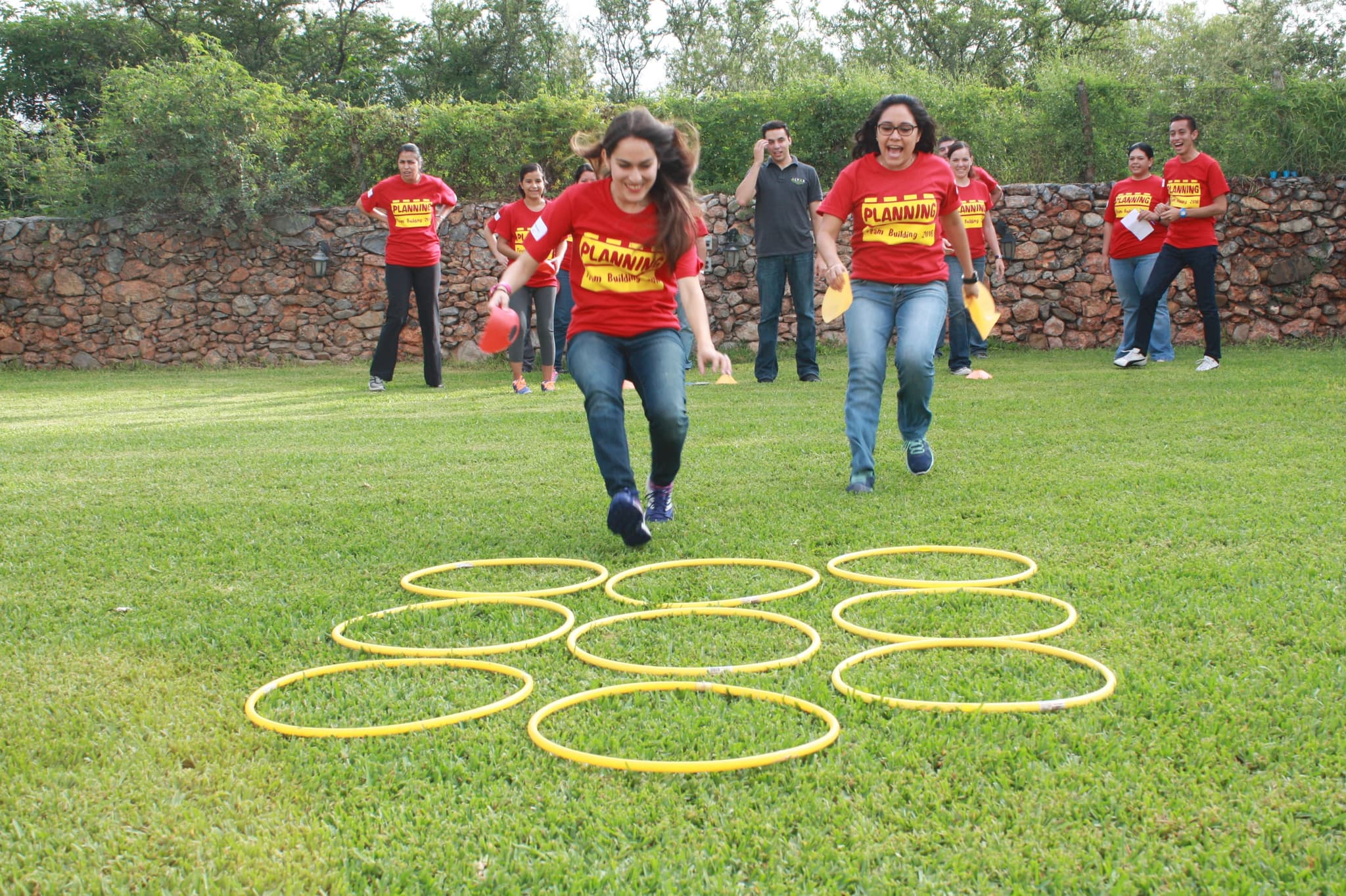 Participantes corriendo juntos hacia una meta, reflejando la energía y el espíritu competitivo del rally empresarial